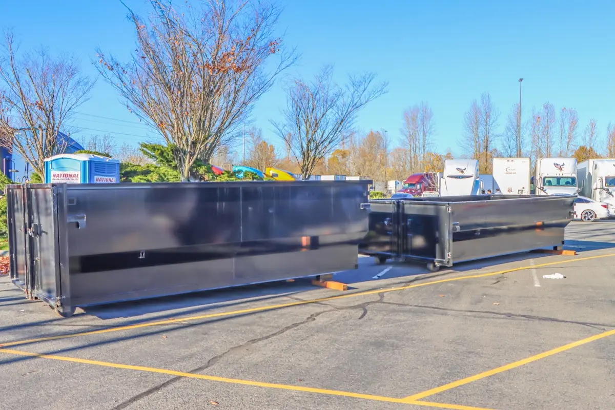 Professional dumpster rental service with roll-off container on residential driveway in Anoka